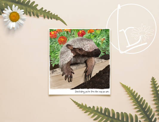 Illustration of an armadillo sitting in a flower bed. There is mud everywhere and the flowers are red and orange. The slogan reads "Stop hiding, you're fine the way you are."