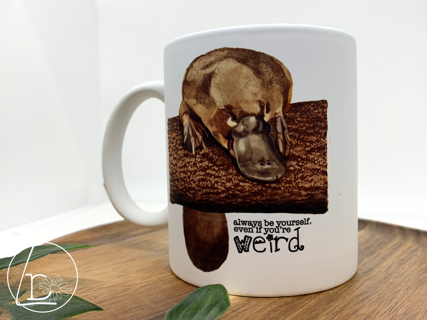 Illustrated platypus mug. The text says "Always be yourself, even if you're weird."