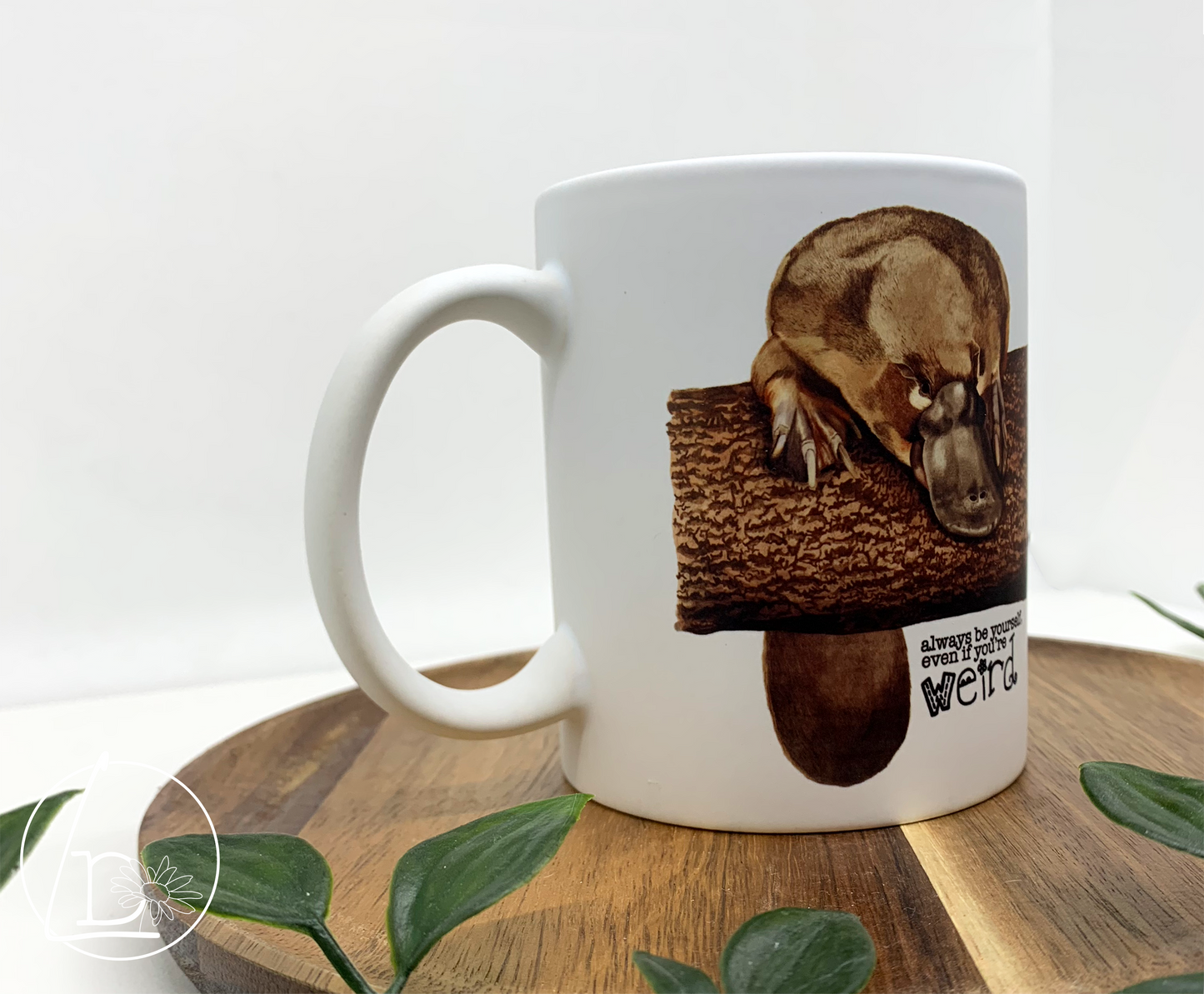 Illustrated platypus mug. The text says "Always be yourself, even if you're weird."