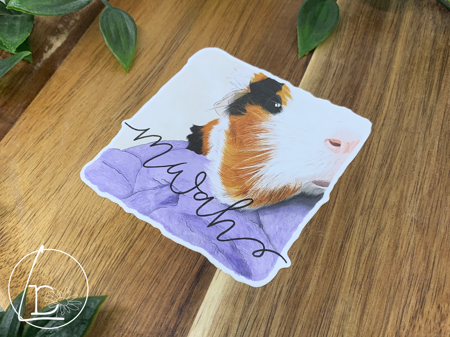 Illustrated sticker of a black, white and ginger guinea pig. The text says "mwah"