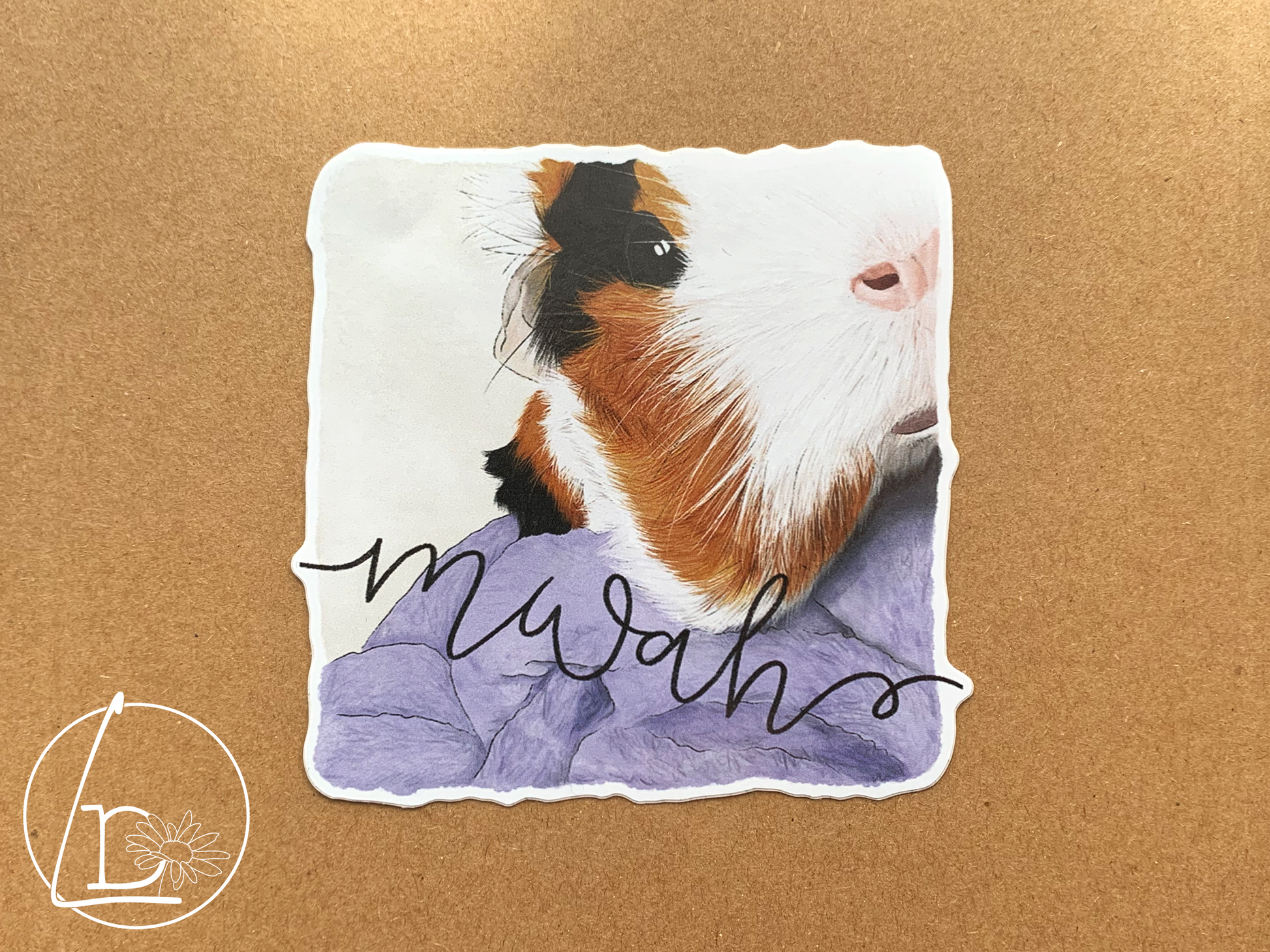 Illustrated sticker of a black, white and ginger guinea pig. The text says "mwah"