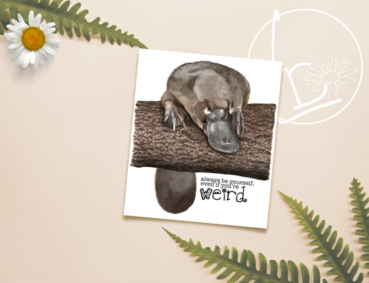 Illustration of a platypus leaning over a large log, his tail hanging down the back. The slogan says "always be yourself, even if you're weird"