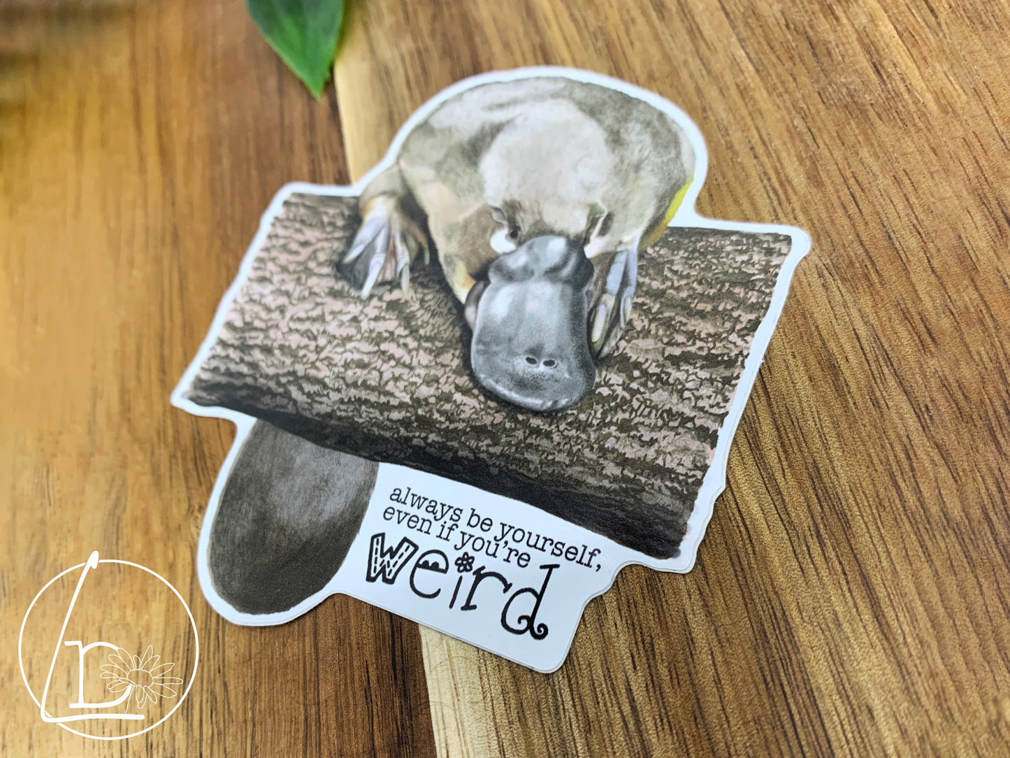 Illustrated platypus sticker. The text says "Always be yourself, even if you're weird."