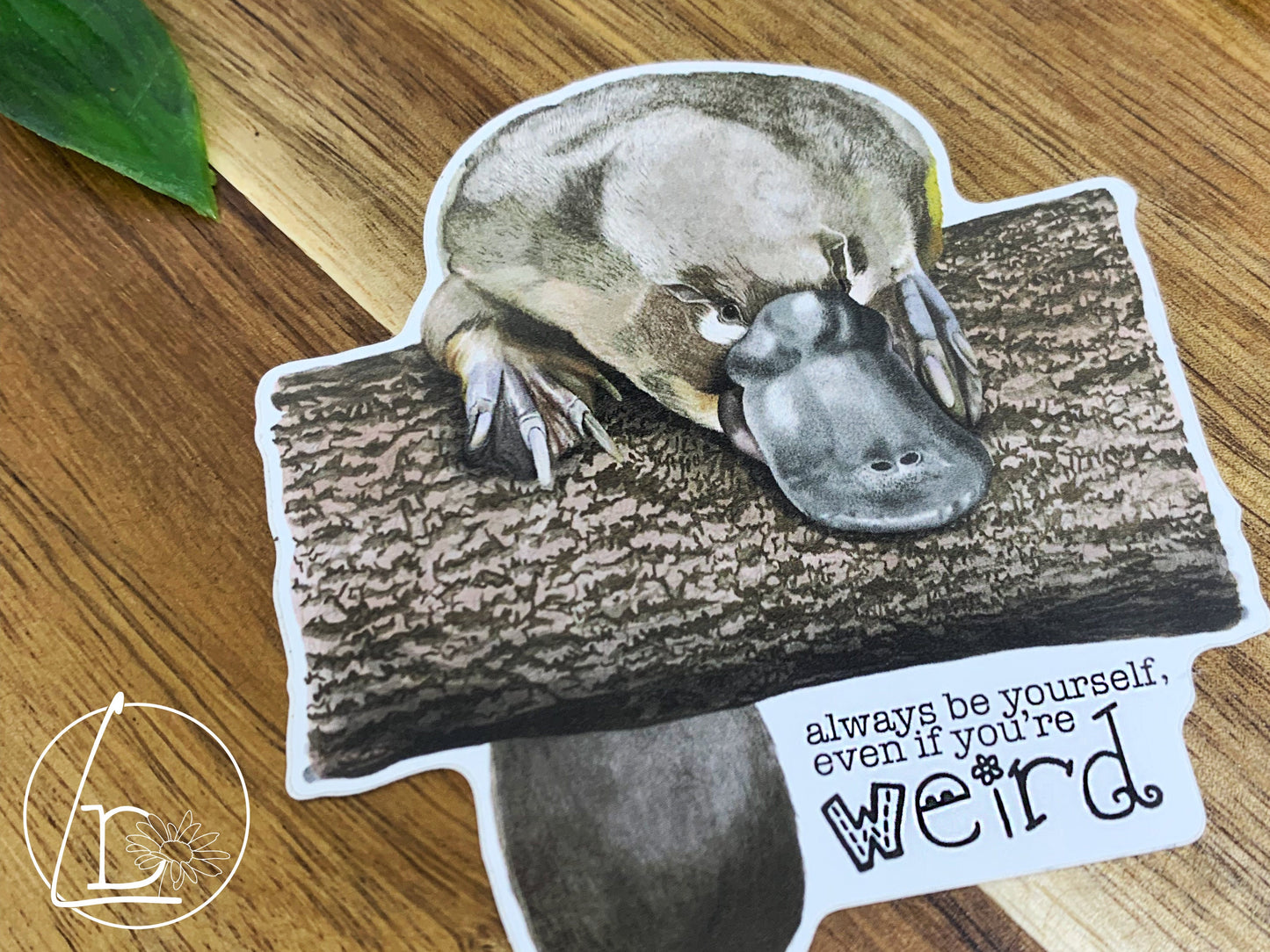 Illustrated platypus sticker. The text says "Always be yourself, even if you're weird."